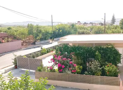 a building with a garden with flowers on it at Yucca Studio, beautiful apartment with garden in Ropanianá