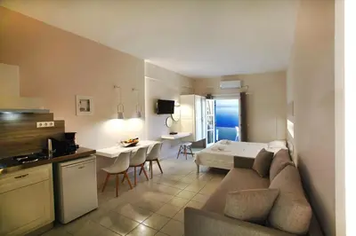 a living room and kitchen with a couch and a table at Studios Vasilis in Agia Marina Nea Kydonias