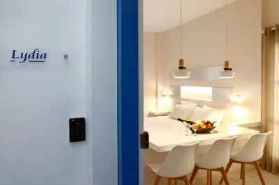 a dining room with a white table and chairs at Studios Vasilis in Agia Marina Nea Kydonias
