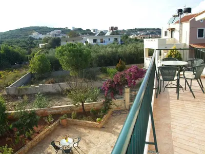 a balcony of a house with a table and chairs at Irida Apartments -EX BLAZIS HOUSE in Almirida