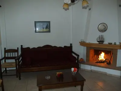 a living room with a couch and a fireplace at Irida Apartments -EX BLAZIS HOUSE in Almirida