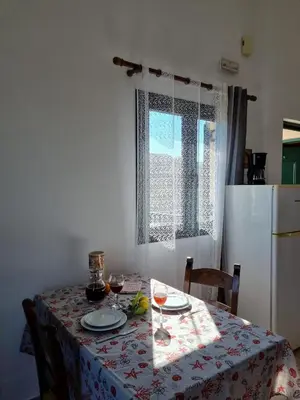 a kitchen with a table with a table cloth on it at Irida Apartments -EX BLAZIS HOUSE in Almirida