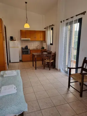 a kitchen and dining room with a table and chairs at Irida Apartments -EX BLAZIS HOUSE in Almirida