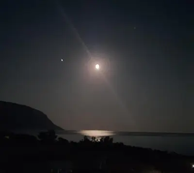 a view of the moon over the water at night at Paradise in Agia Roumeli