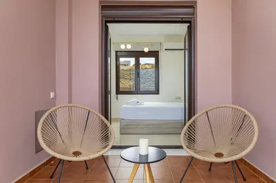 two chairs and a table in front of a bathroom at Villa Mari Chania, with private ecologic pool and amazing view! in Chania Town