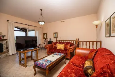 a living room with a couch and a tv at Villa Silva, Garden & Sea View, 3 BR, -10 min drive from center in Chania Town