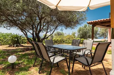 a table and chairs sitting under an umbrella at Villa Silva, Garden & Sea View, 3 BR, -10 min drive from center in Chania Town