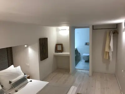 a bedroom with a bed and a bathroom with a toilet at Fourteen All Seasons House in Chania Town