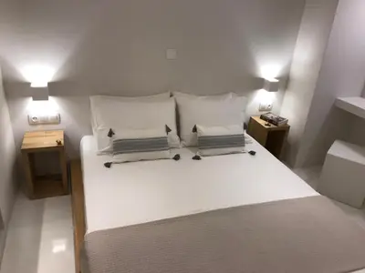 a bedroom with a large white bed with two night stands at Fourteen All Seasons House in Chania Town