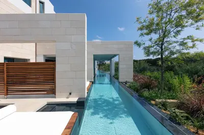 an infinity pool in the backyard of a house at Villa Alveo Del Mare in Chania Town