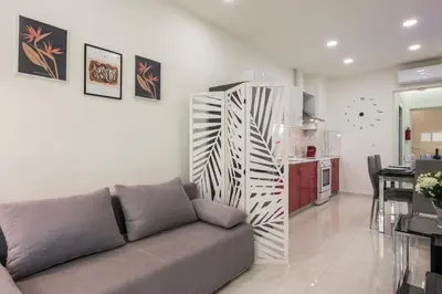 a living room with a couch and a kitchen at Luxury Pearl, steps to the beach in Chania Town