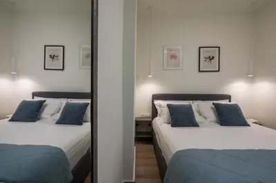 two beds in a room with a mirror at Luxury Pearl, steps to the beach in Chania Town