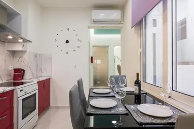 a kitchen with a table with wine glasses on it at Luxury Pearl, steps to the beach in Chania Town