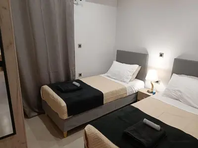 two beds in a small room with a mirror at Vrachakia Elegant in Ayiá