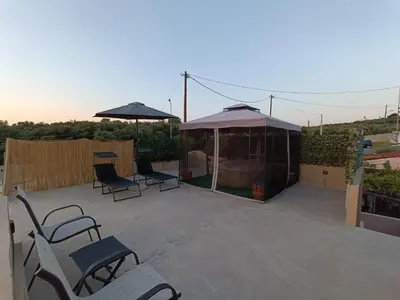 a patio with chairs and umbrellas on a roof at Vrachakia Elegant in Ayiá