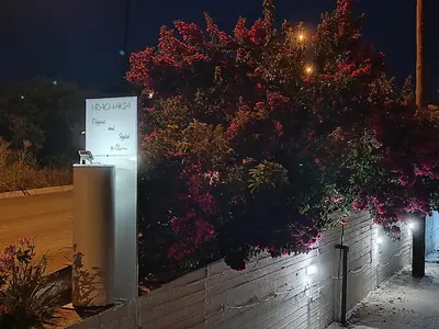a sign in front of a wall with flowers at Vrachakia Elegant in Ayiá