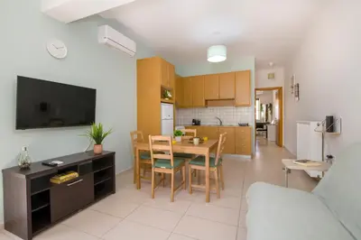 a kitchen and living room with a table and chairs at Peris #1 - Souda in Souda