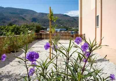 a bunch of purple flowers in front of a house at Peris #1 - Souda in Souda