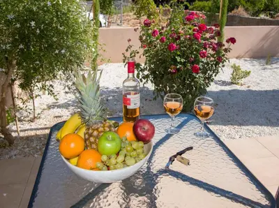 a bowl of fruit with a bottle of wine and two glasses at Peris #1 - Souda in Souda