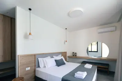 a bedroom with a large bed and a mirror at Ikritis Villas in Chorafakia