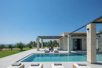 a patio with a swimming pool and a house at Ikritis Villas in Chorafakia