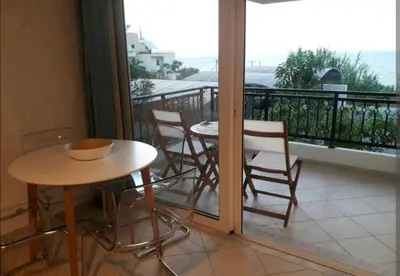 a balcony with a table and chairs and a balcony with a view at Ocean View in Chania Town