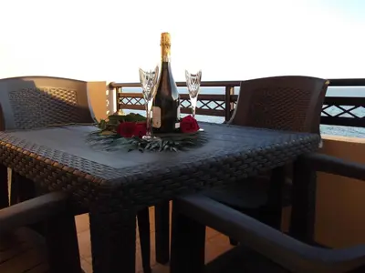 a table with wine glasses and flowers on it at Kritamos Beach Apartments in Frangokastello
