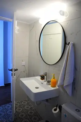 a bathroom with a white sink and a mirror at Panorama Sea View Apartment in Beritianá