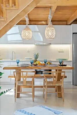 a kitchen with a table and chairs and pendant lights at The Violin House in Chania Town