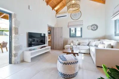 a living room with a white couch and a tv at The Violin House in Chania Town