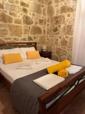 a bed with yellow and white pillows on it at VILLA MICHAELA in Gramvousá