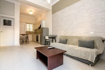 a living room with a couch and a table at PLUS 2! in Chania Town