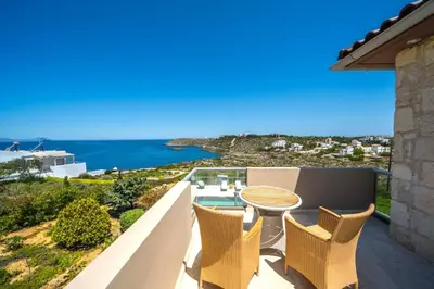 a balcony with a table and chairs and the ocean at Villa Poseidon One - Sunset & Sea Front Villa in Chorafakia