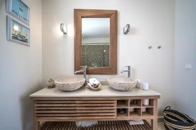 a bathroom with two sinks and a mirror at Villa Poseidon One - Sunset & Sea Front Villa in Chorafakia