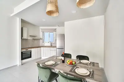 a dining room with a table and chairs and a kitchen at El Platanias in Chania Town