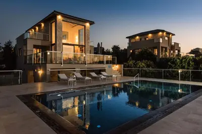 a house with a swimming pool in front of a house at Magnifique villa avec piscine au bord de mer in Chorafakia
