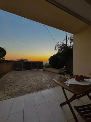 a patio with a table and a view of the ocean at Solis Occasum in Aghii Apostoli