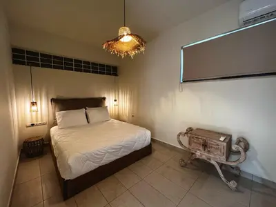 a bedroom with a bed and a chandelier at Solis Occasum in Aghii Apostoli