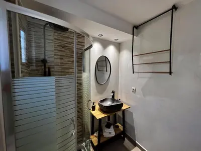 a bathroom with a glass shower and a sink at Solis Occasum in Aghii Apostoli