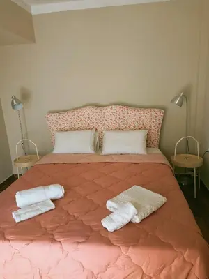 a bedroom with a pink bed with two towels on it at Amazing View in Kissamos