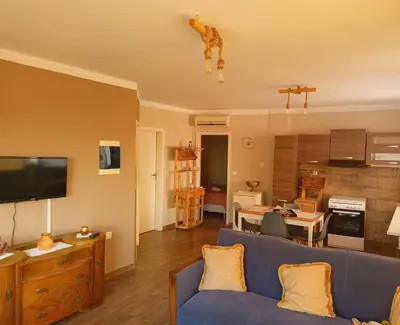 a living room with a blue couch and a kitchen at Amazing View in Kissamos