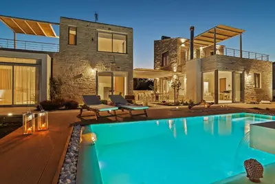 a house with a swimming pool in front of a house at Annassa Experience Villa 2' walk from Almyrida beach in Almirida