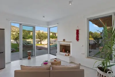 a living room with a couch and a fireplace at Annassa Experience Villa 2' walk from Almyrida beach in Almirida