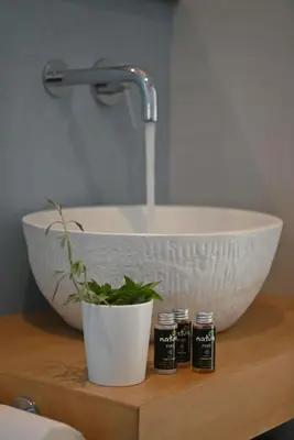 a bathroom counter with a sink and a bowl at Annassa Experience Villa 2' walk from Almyrida beach in Almirida