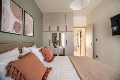 a bedroom with a large white bed with brown pillows at Cretan Sea View Apt 8mins to beach,old town, city in Chania Town
