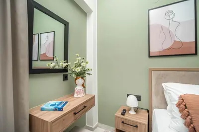 a bedroom with a bed and a table with a vase of flowers at Cretan Sea View Apt 8mins to beach,old town, city in Chania Town
