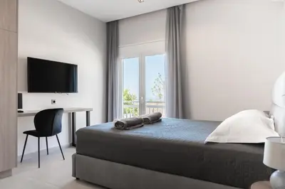 a bedroom with a bed and a desk and a television at Yiannis Deluxe Apartment in Chania Town