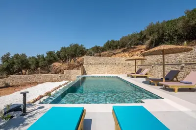 a swimming pool with two lounges and two chairs at Alma Natura Villas Falasarna- Avgerinos Villa in Falasarna