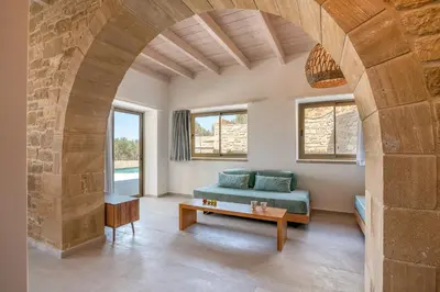 a living room with a blue couch and a table at Alma Natura Villas Falasarna- Avgerinos Villa in Falasarna