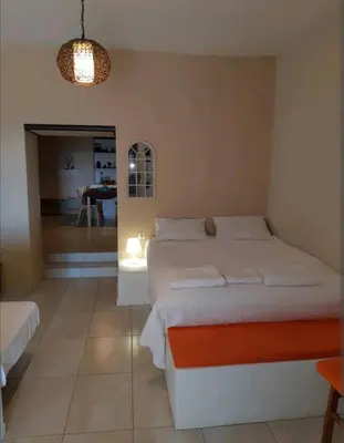 a bedroom with a large bed and a dining room at Orea Kaliva in Sfinárion